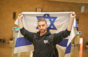 Simcha proudly displays the flag upon his arrival to Israel
